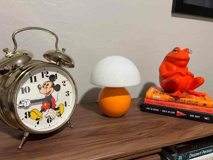 Matching the vibe with this striking orange lamp and some playful orange accents! 🟠✨ Together, they add a burst of warmth and fun to my space. #ColorCohesion #HomeDecor #VibrantVibes #MushroomLamp #RetroDecor #VintageClock