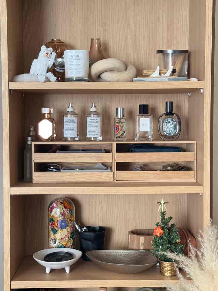 ナチュラルな木目調の北欧スタイル収納棚、整然とした装飾品とトレイが配置された落ち着いた空間