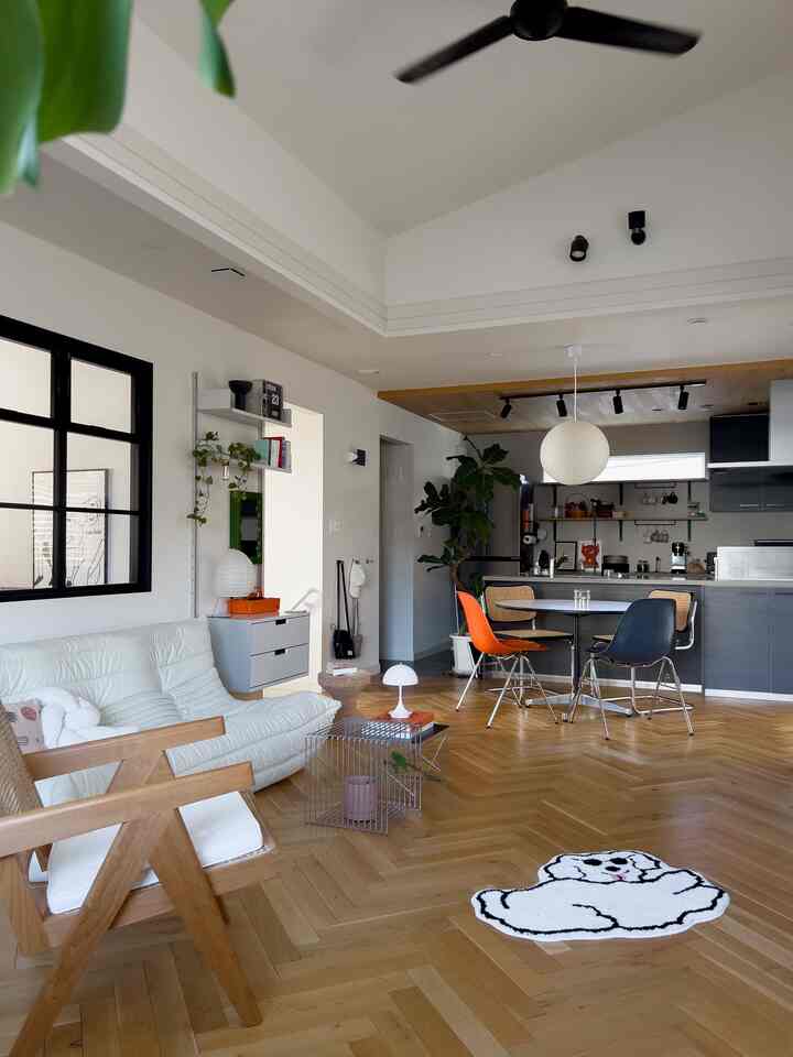 白と木目調の調和が取れたモダンなリビング・キッチン空間、シンプルな家具と照明が配置された雰囲気のあるインテリア