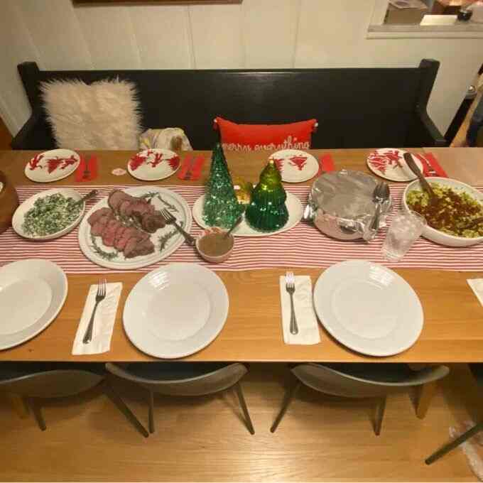Red and white toned dining room featuring mid-century modern bench and table set for a festive home party atmosphere