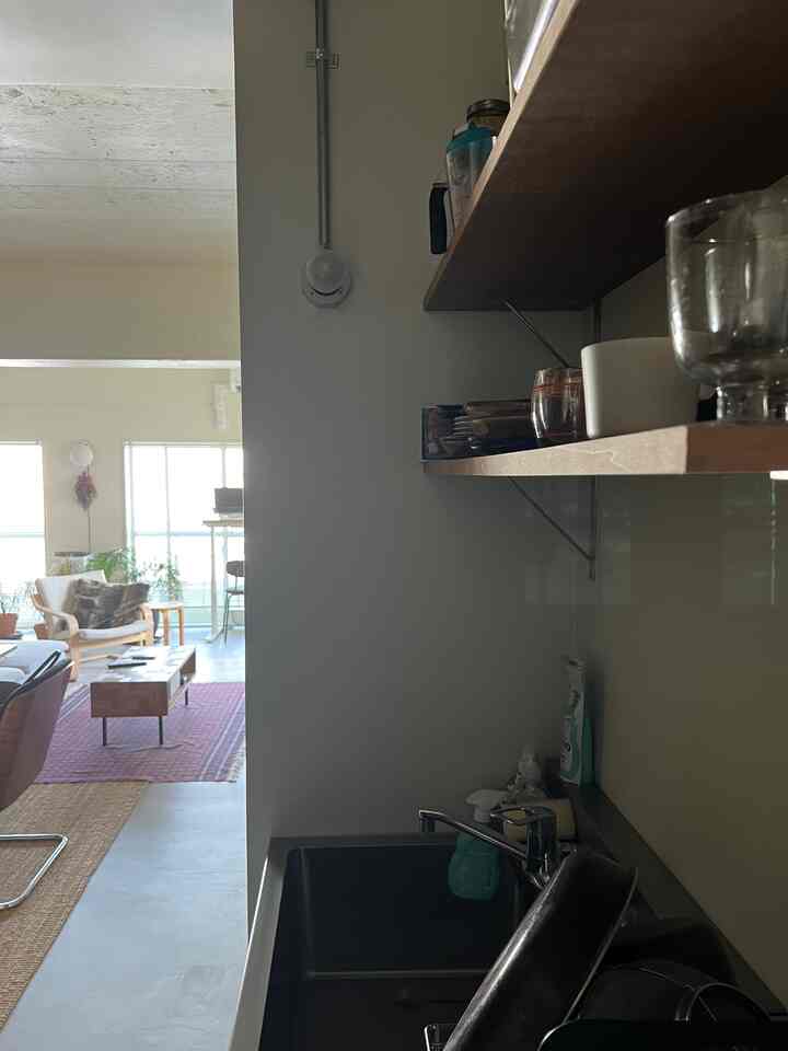 A natural wood-toned open living room and kitchen space featuring modern and mid-century modern furniture with a cozy atmosphere