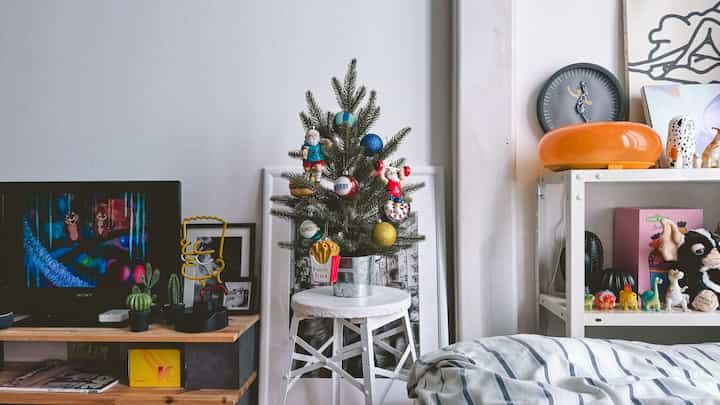 白と木目調が調和した小さな寝室、素朴な家具と装飾が配置された雰囲気のあるインテリア