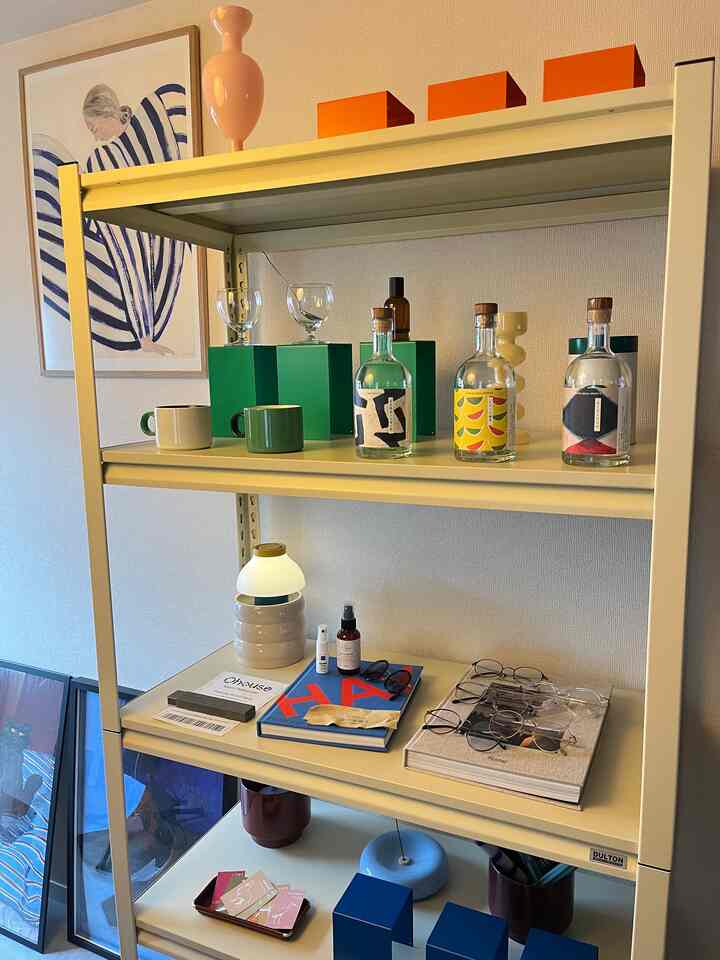 ベージュトーンの棚にカラフルなインテリア小物と照明が配置された雰囲気のあるインテリア