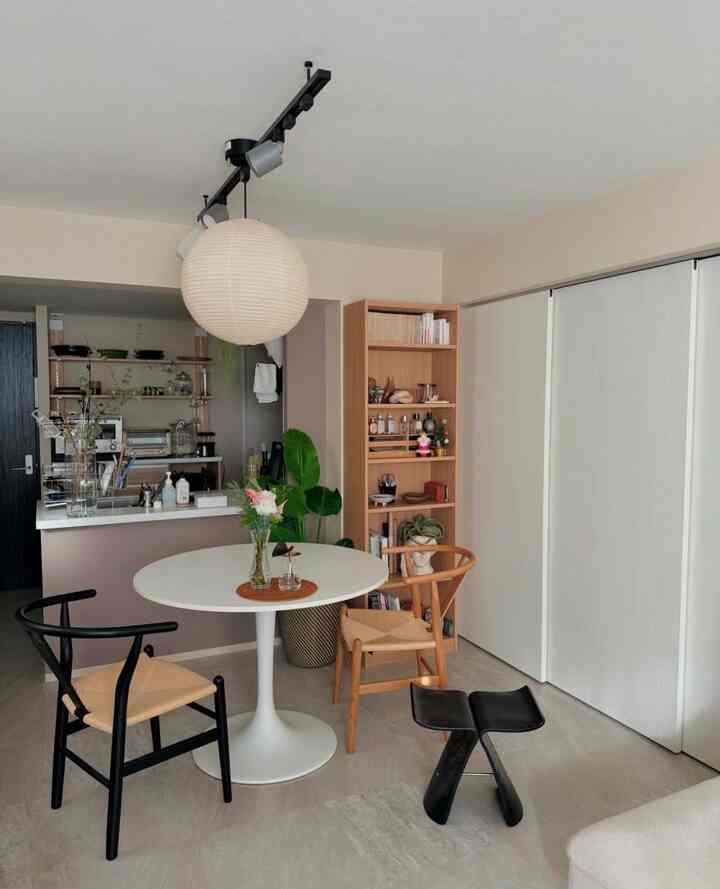 White and wood tone two-person dining room with modern, minimal layout and pendant lighting