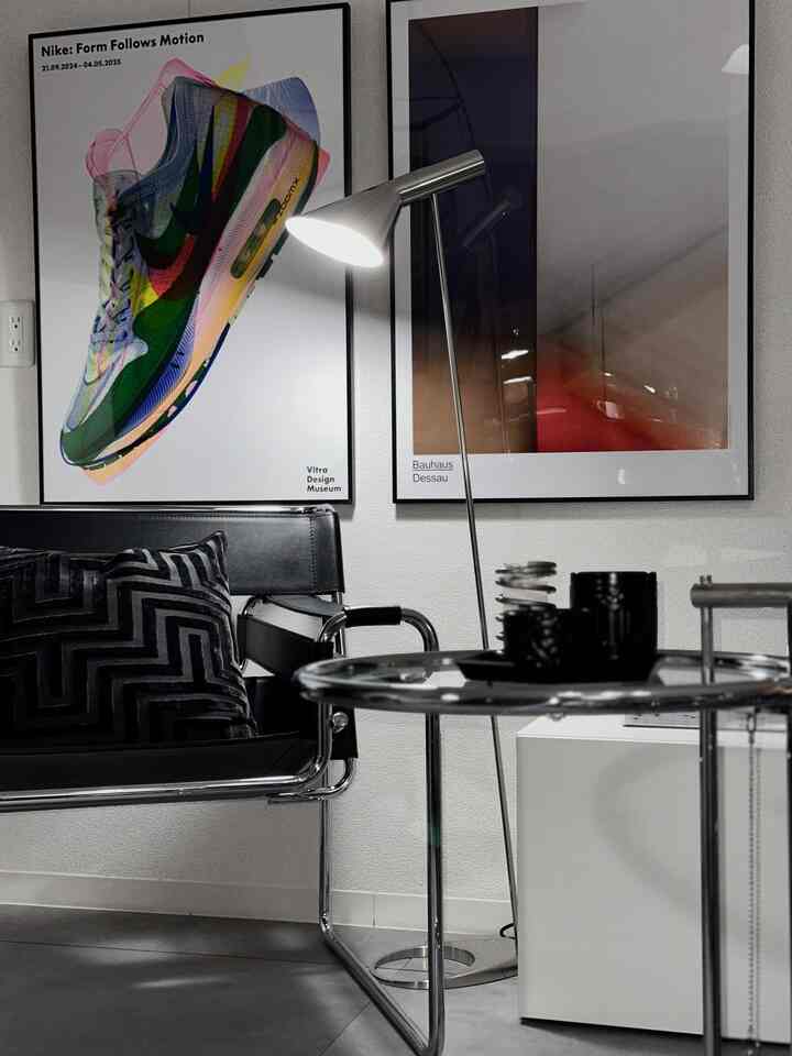 モダンな黒とシルバーのリビング、アームチェアとサイドテーブル、フロアランプが配置された雰囲気のあるインテリア