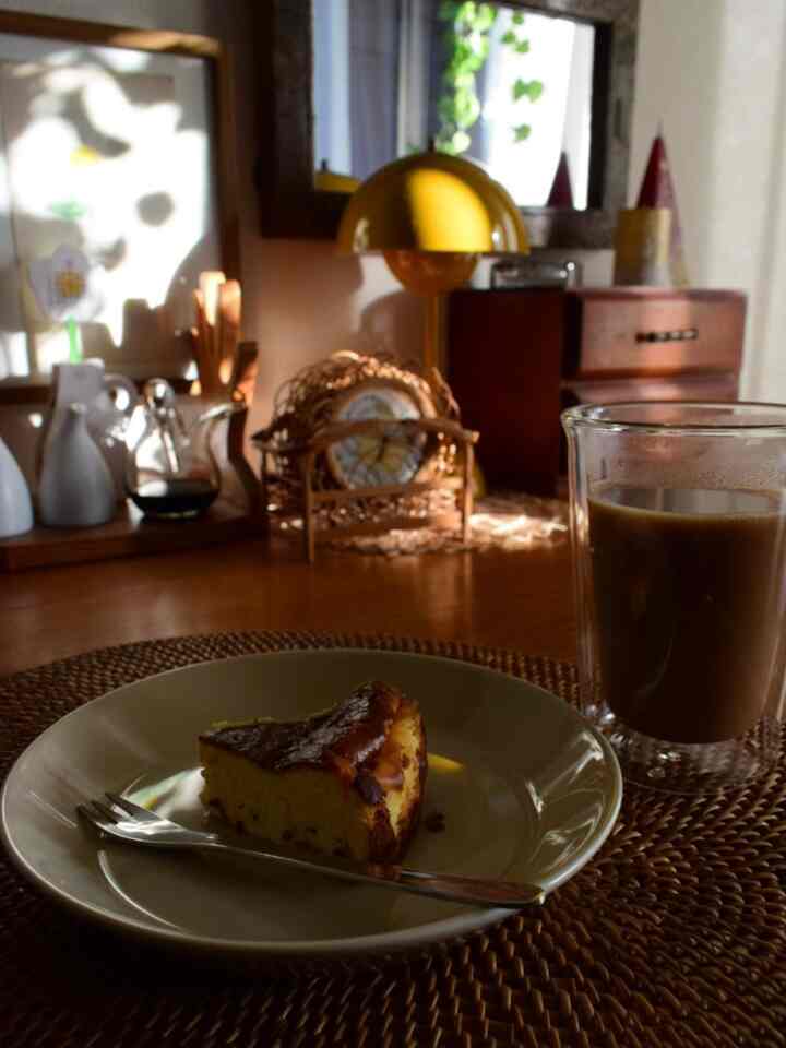 温かみのあるブラウン調のヴィンテージ風おうちカフェ、木製テーブルにケーキとコーヒーが置かれている印象的な空間