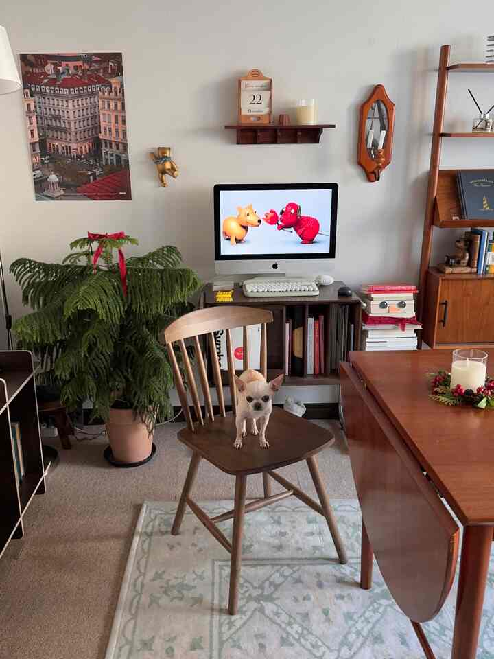 木目調の家具が配置されたダイニングルーム、中央の椅子に犬が座る、温かみのあるヴィンテージな雰囲気の空間