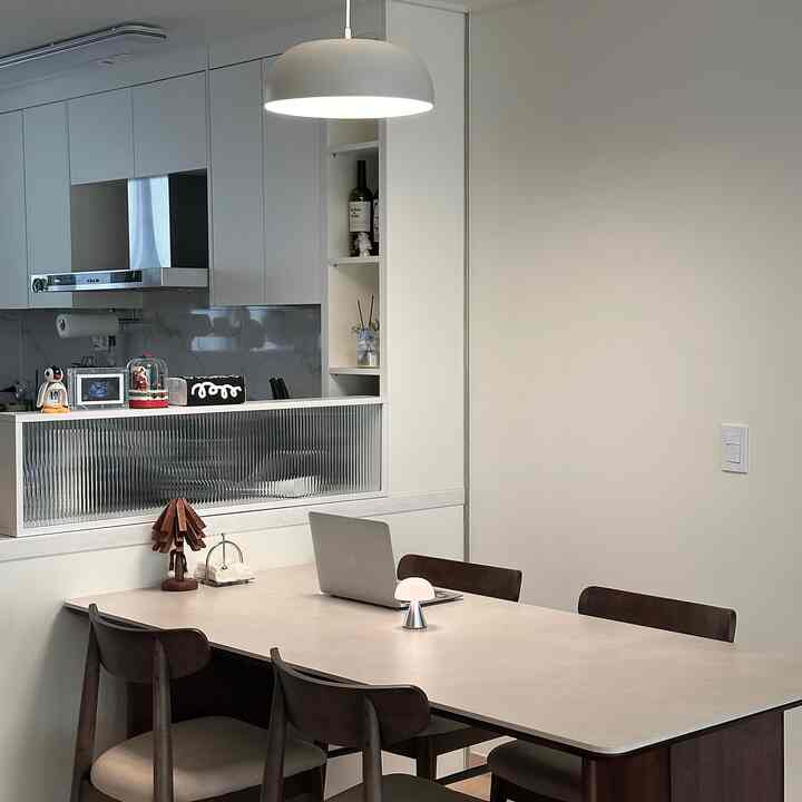 白と木目調が調和したシンプルモダンなダイニングルーム、セラミック天板のダイニングテーブルと4脚の椅子が配置された印象的な空間