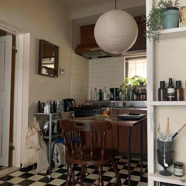 チェック柄の床とナチュラルウッド家具が配置された居心地の良い一人暮らしのキッチン空間