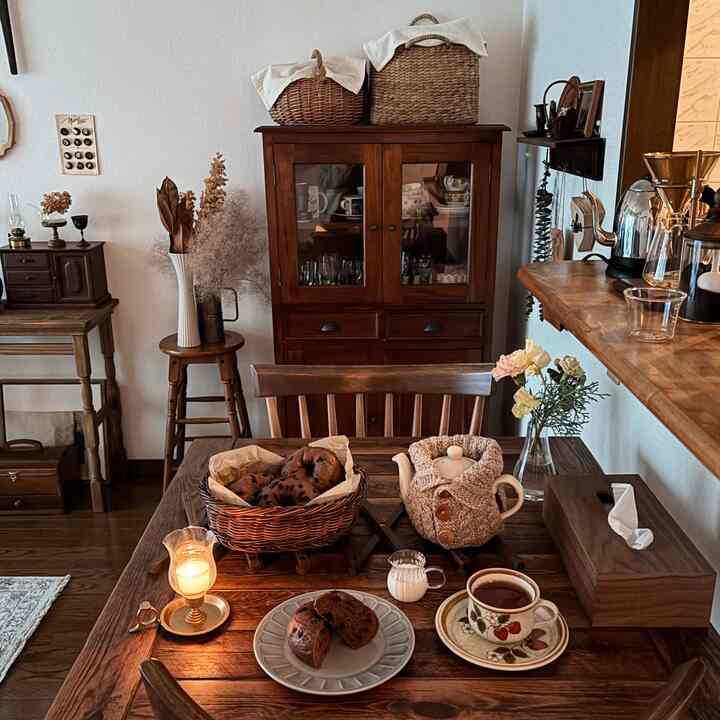 Natural wood-tone vintage dining room featuring a tea setup with baked goods creating a cozy home cafe atmosphere