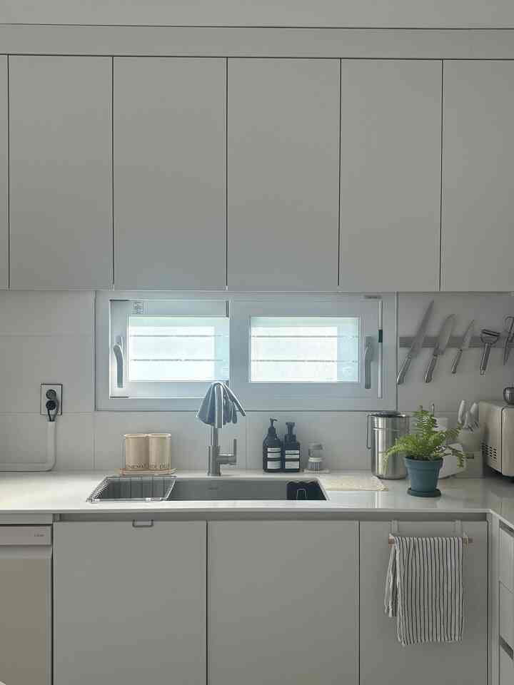 ホワイトトーンのキッチン、清潔感のあるシンクと収納アイデアが際立つシンプルな空間