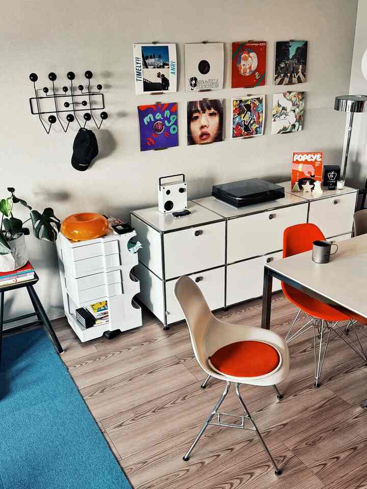 白と木目調が調和するダイニングスペース、レトロなレコードアルバムとオレンジ色の椅子が印象的な音楽空間