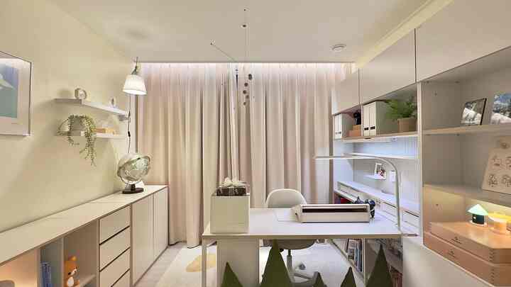 暖かいベージュとホワイトのトーンの子供部屋で、広い机とカーテン、本棚が配置された雰囲気のあるインテリア