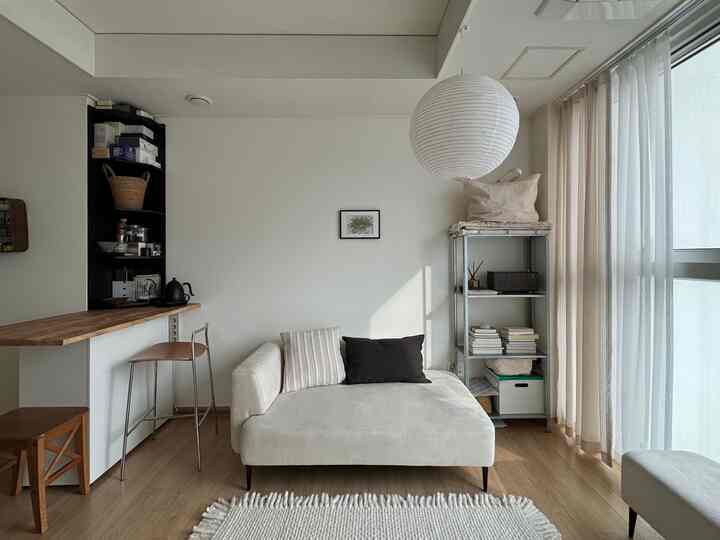 ホワイトとウッドトーンが調和した一人暮らし向けの小さなリビング、シンプルで自然な雰囲気の清潔感あるインテリア