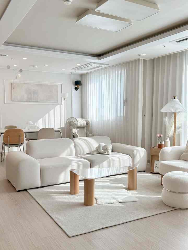 明るいホワイトと木目調の6畳リビング、モダンでシンプルなソファとガラスのコーヒーテーブルが配置された印象的な空間