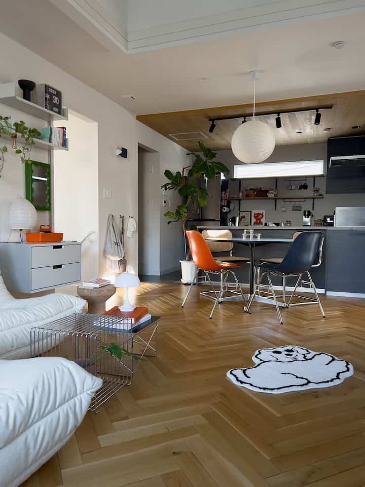 ナチュラルカラーと木目調のキッチンダイニング、ヴィンテージのダイニングチェアとペンダントライトが配置された雰囲気あるインテリア