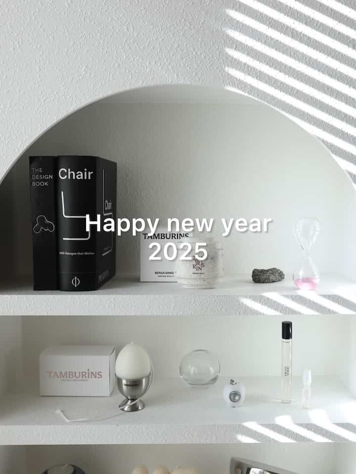 白を基調とした玄関用マントルピースの棚、シンプルでモダンなオブジェとキャンドルが配置された印象的な空間