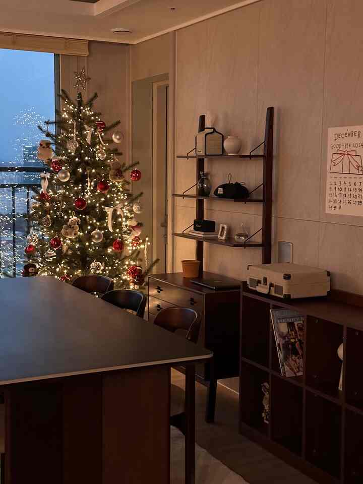 ナチュラルカラーと木目調が調和したリビングダイニングルーム、照明とクリスマスツリーが印象的な空間