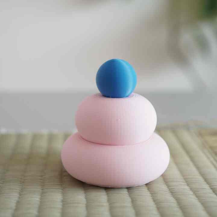 Pastel pink and blue three-tiered objet placed on a clean, minimal interior surface