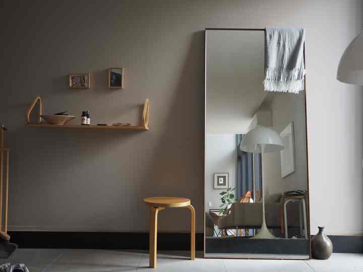 ナチュラルな色調の玄関、シンプルに配置されたスツールと大きな鏡が印象的な北欧スタイルのインテリア