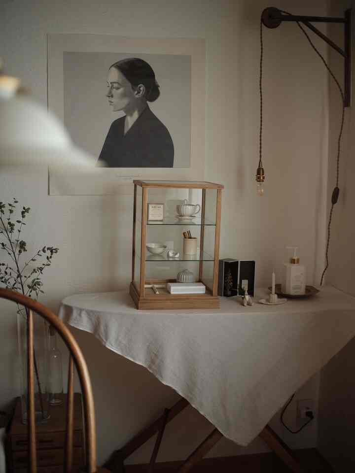 ナチュラルカラーと木目調が調和したリビングダイニング、テーブルの上にポスターや小物が置かれた雰囲気のあるインテリア