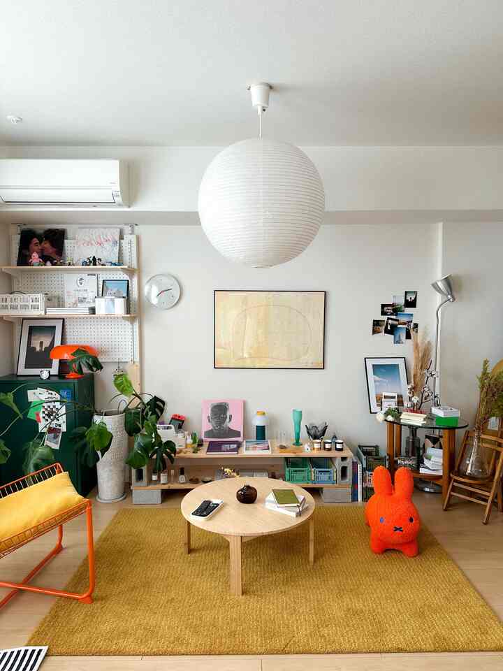 A white and yellow toned living room featuring a wooden coffee table and plants with a simple, natural atmosphere