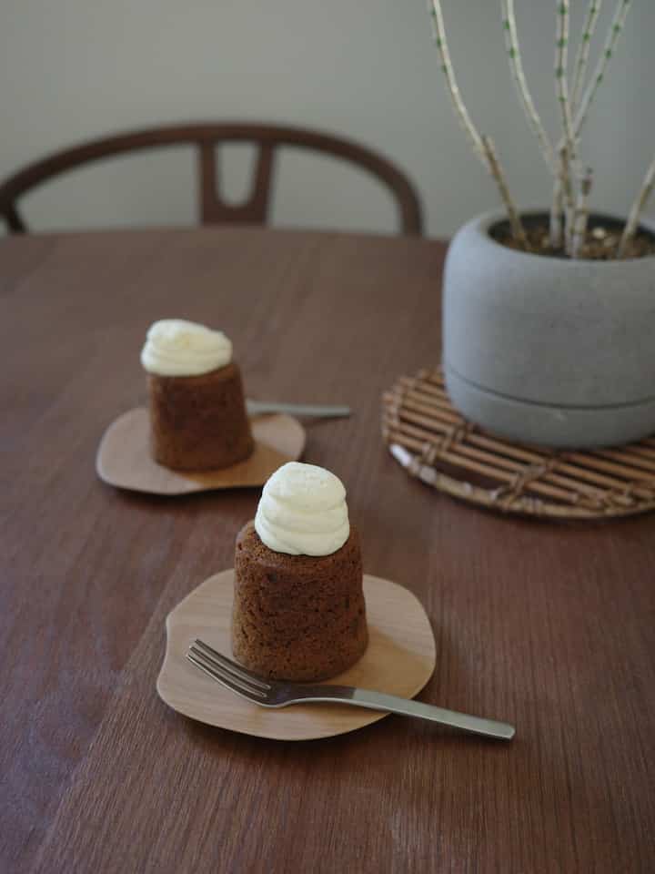 木目調のダイニングテーブルにホームカフェのケーキと木の小皿が配置された、雰囲気のあるインテリア