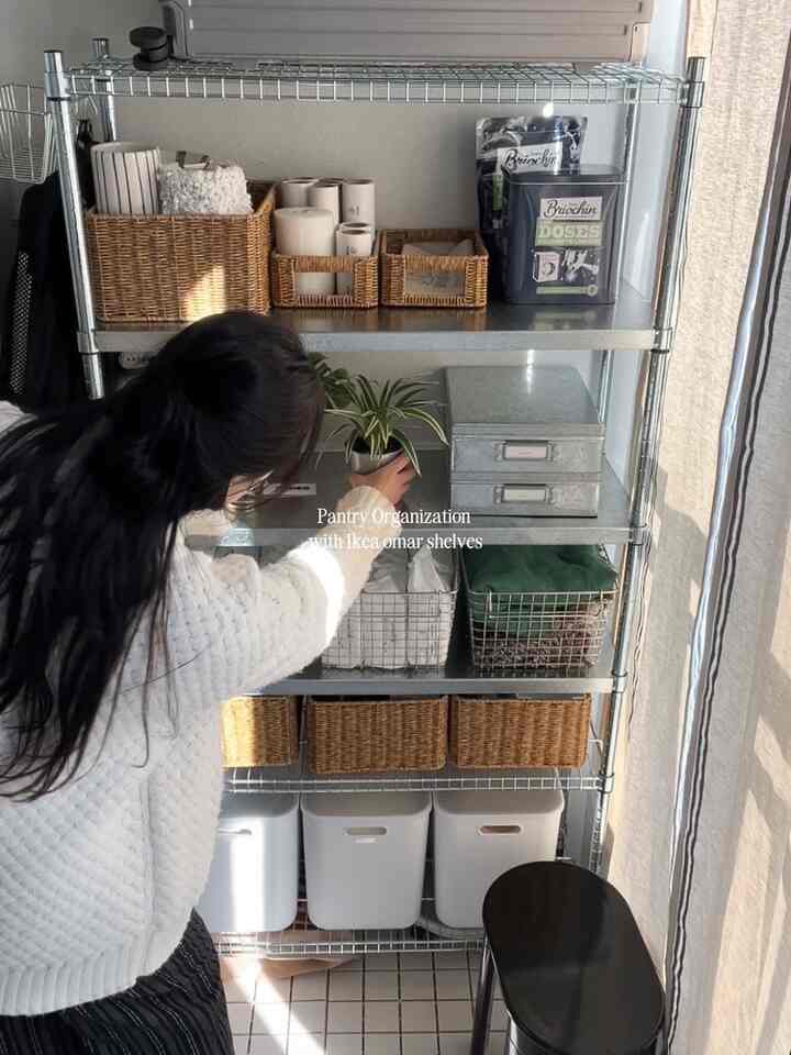 白と茶色のトーンが印象的な洗濯室パントリー、イケアのオマー棚とバスケットが配置された自然な雰囲気のあるインテリア