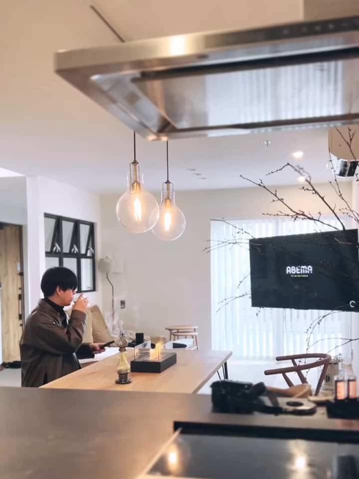 ホワイトトーンのリビングとダイニング、ナチュラルウッドのテーブルとペンダントライトが配置されたシンプルでモダンな雰囲気のあるインテリア