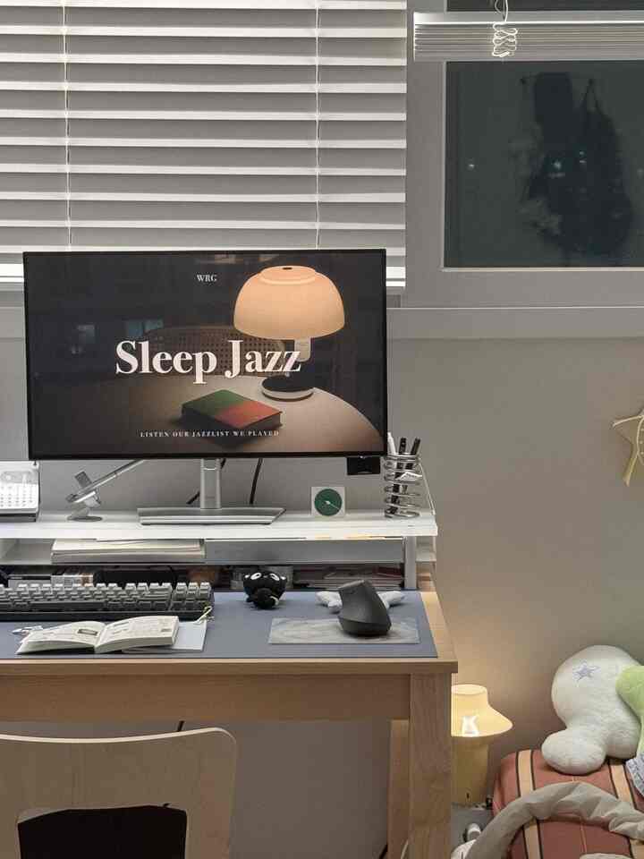 白と茶色のトーンが印象的なコンパクトなホームオフィス、モニターとデスクが配置されたすっきりとした実用的なインテリア