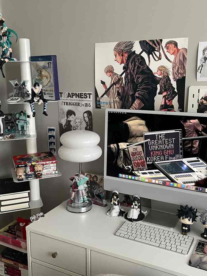 中間色グレーの壁と白い家具が調和するホームオフィス空間、デスク上にアニメフィギュアとコンピュータが配置された居心地の良い作業スペース