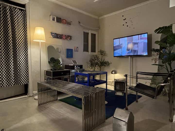 A vintage living room with silver steel bench and blue steel table under natural lighting