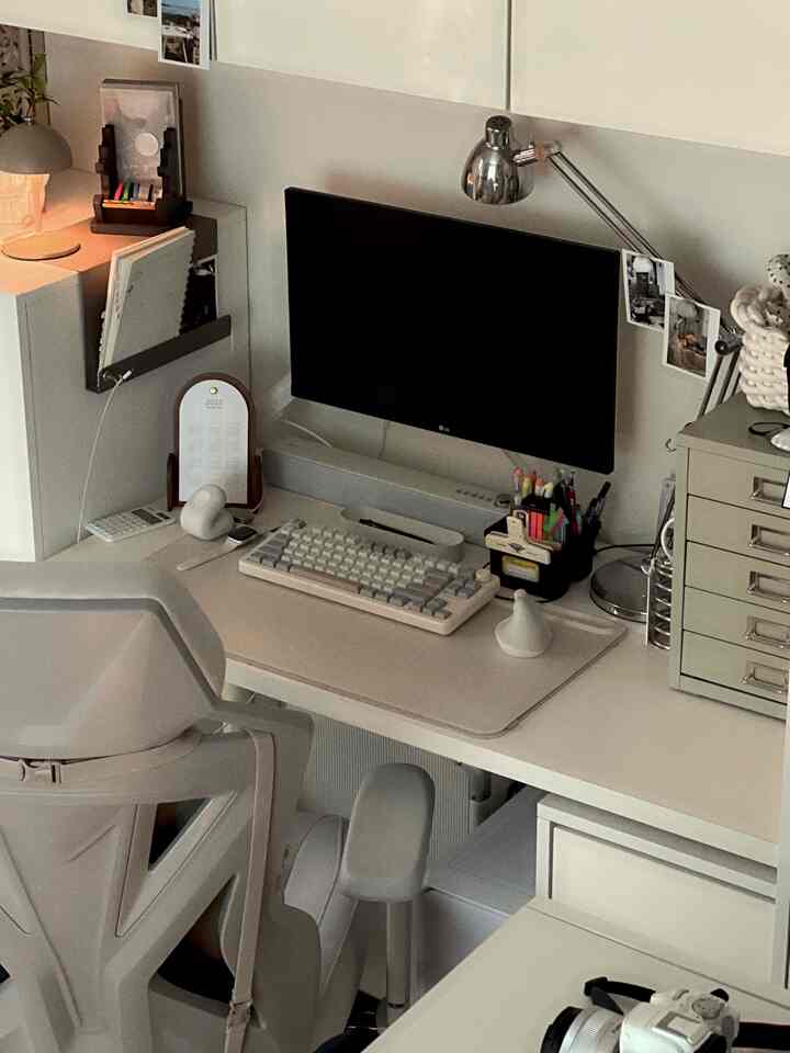 モノトーンとグレーを基調としたワンルームのホームオフィス、整頓されたデスクとオフィスチェアが配置された落ち着いた空間