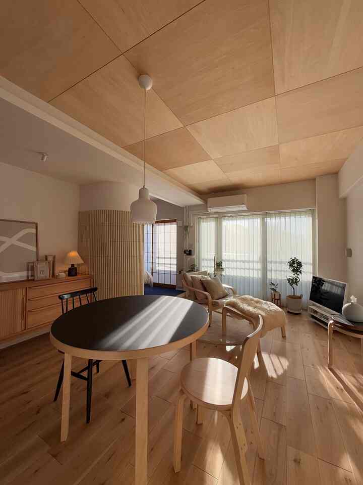ナチュラルな木目調とモダンなデザインの1LDKリビングダイニング、ブラインド付き大きな窓とペンダントライトが印象的な空間