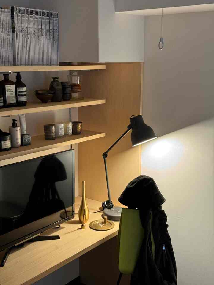 木目調と白を基調とした1LDKの一人暮らし空間、デスク・本棚・テーブルランプが配されたモダンなホームオフィスの雰囲気