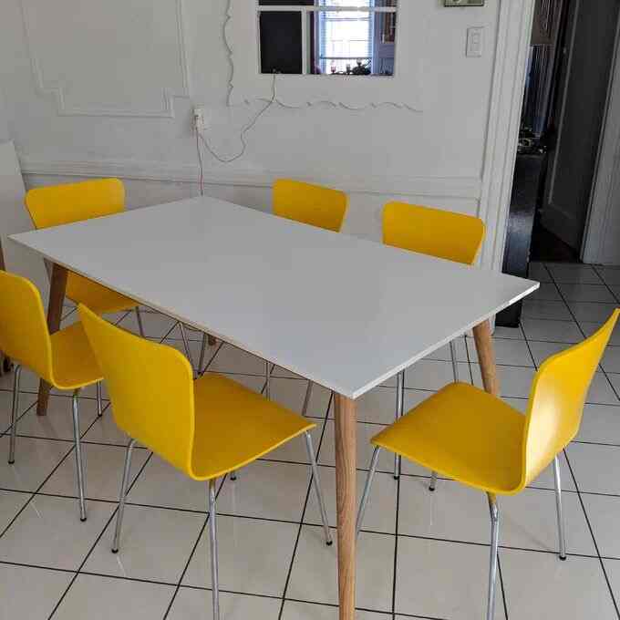 Bringing sunshine to mealtime with this white dining table and cheerful yellow chairs! ☀️💛 A pop of color that brightens up the space and elevates every meal! #DiningRoomGoals #ColorPop #HomeDecor