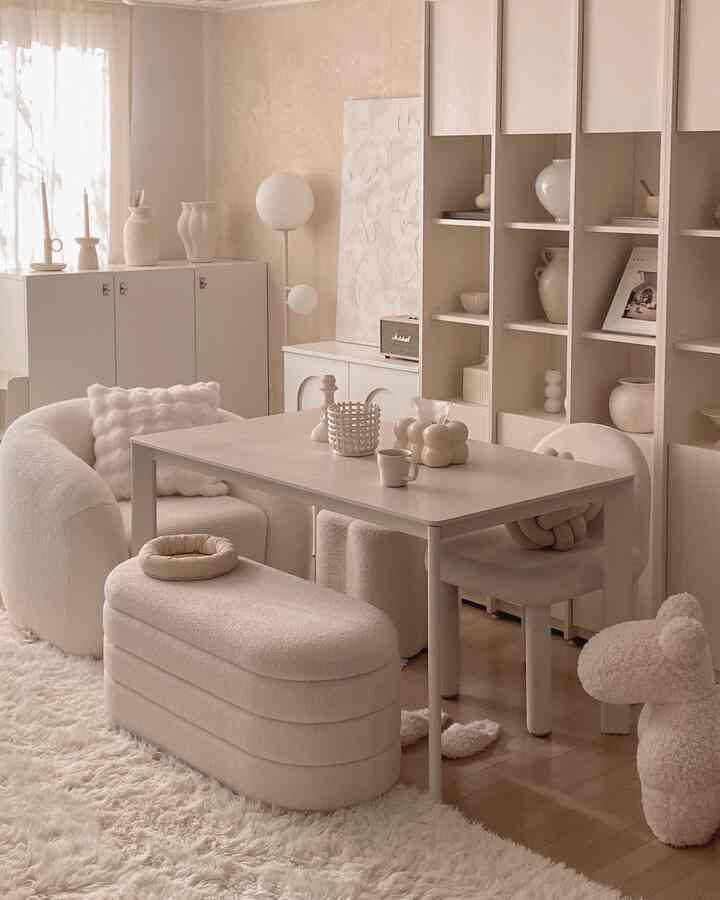 柔らかなホワイトトーンのダイニングルーム、セラミック製のダイニングテーブルとスツール、ラグが調和した落ち着いたモダンな空間