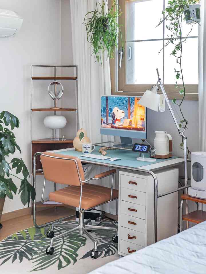 木目調の床とスチールフレーム家具が配置されたナチュラルモダンな書斎、ブラウンレザーの椅子とデスク照明が印象的な空間