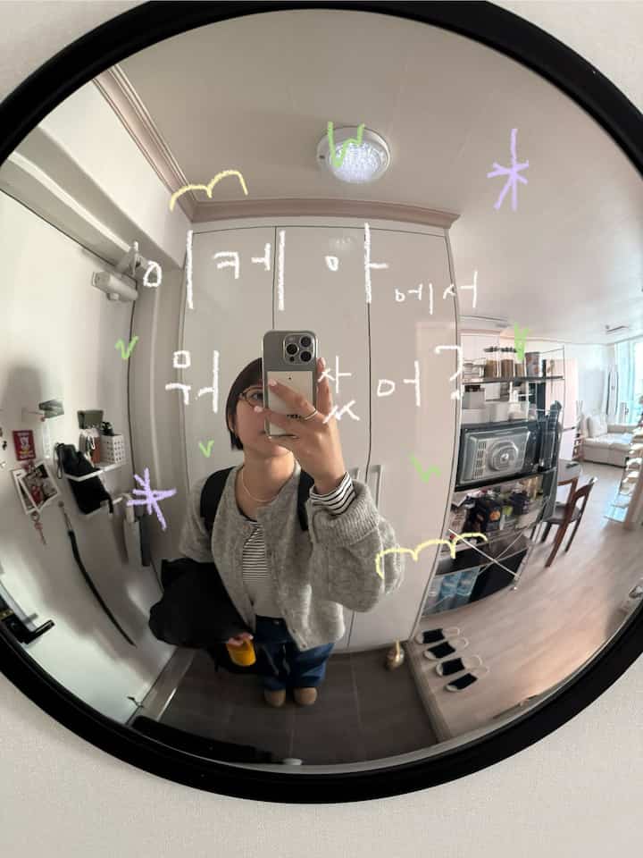 白い壁と靴箱のある玄関、中央に丸い凸面鏡が設置された印象的なフォトゾーン空間