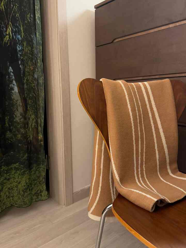 木目調とベージュが調和した狭い部屋に、ダイニングチェアと木製のチェストが配置されたナチュラルな空間