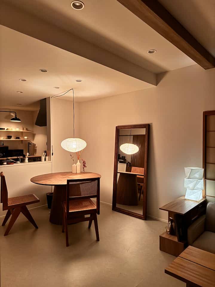 暖かい木目調と白が調和するモダンなダイニングルーム、間接照明が柔らかく照らす雰囲気のあるインテリア