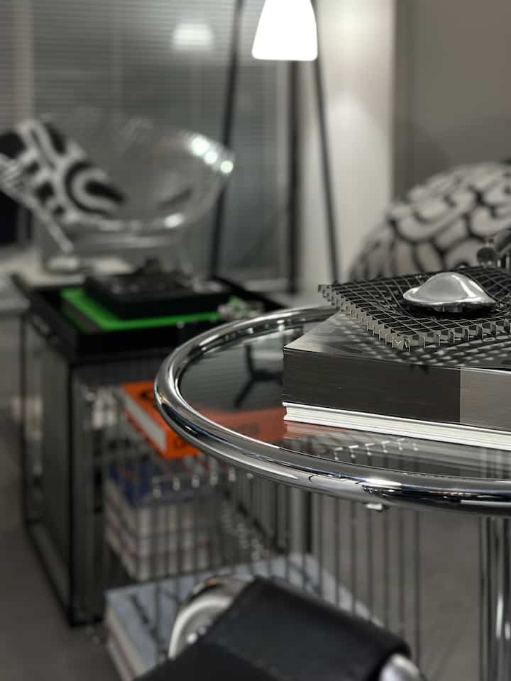 Modern silver-toned living room featuring chrome tables and a tray, creating a sleek atmosphere
