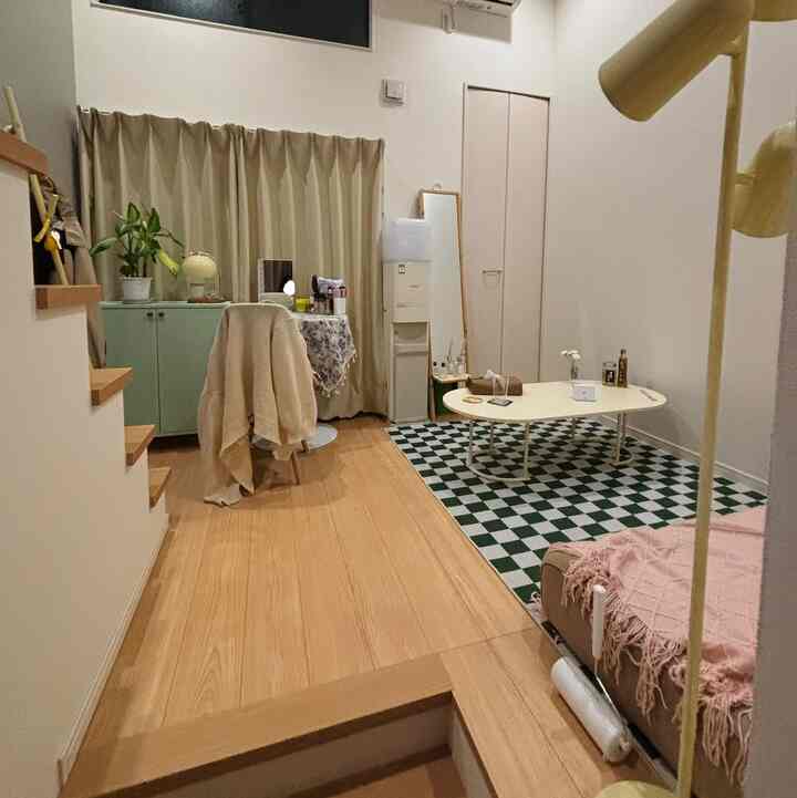 ベージュ色の壁と木目調の床が特徴の4.5畳の縦長リビング、コーヒーテーブルとソファが配置されたナチュラルモダンな空間