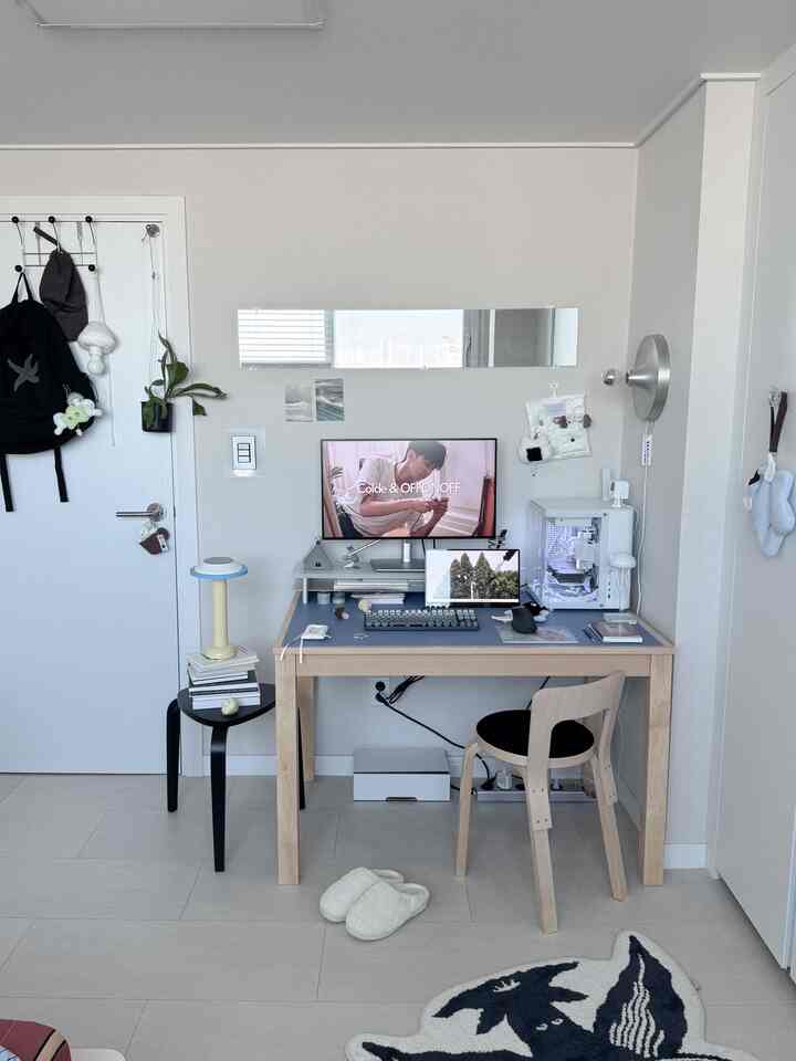 A simple home office space for a single household with white walls and wood-toned furniture