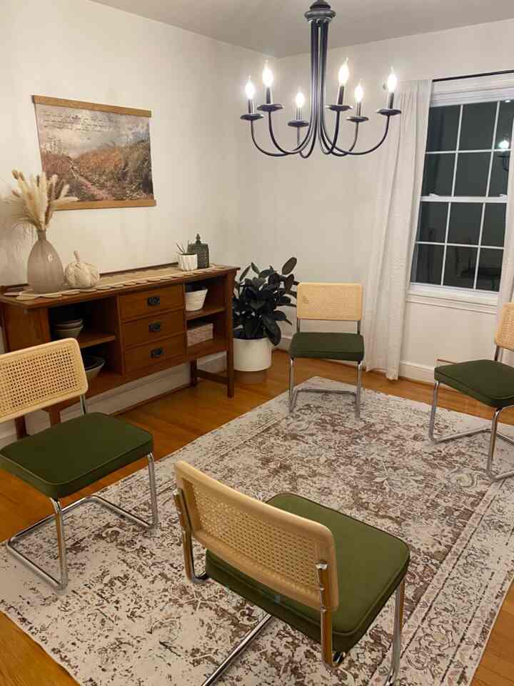 Natural-toned dining room featuring green cushioned rattan chairs and vintage wooden sideboard in a cozy setting