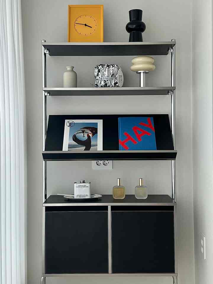 白い壁と黒のリビング棚が印象的なミッドセンチュリーモダンスタイルのインテリア空間