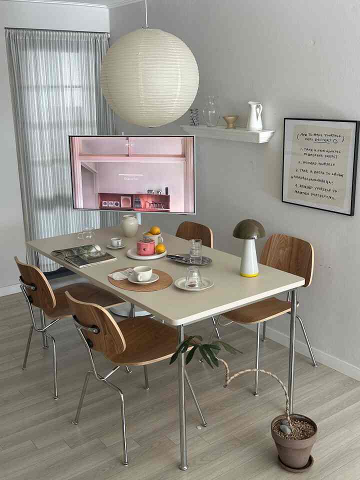 White and wood-tone kitchen dining space featuring mid-century modern chairs and pendant light creating a cozy atmosphere