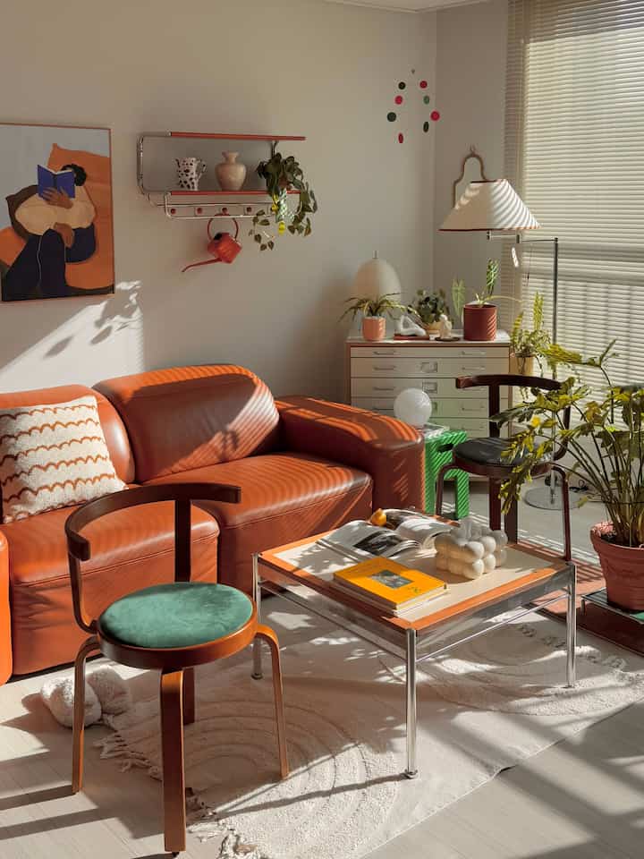 Natural brown and green-toned living room featuring vintage leather sofa and Reed Chairs with a warm atmosphere