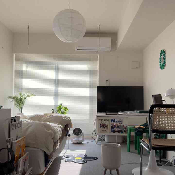 Bright white-toned small bedroom featuring a bed and TV stand with a natural, cozy atmosphere
