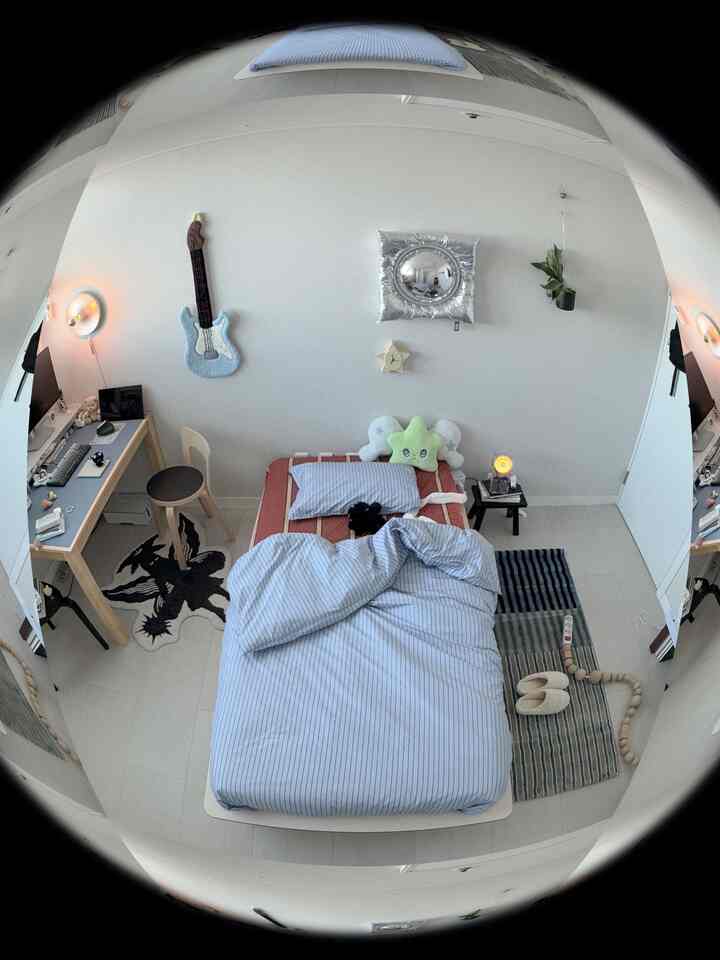 白い壁と床にブルーの寝具が映えるワンルームの寝室、アルテックチェアと机が配置されたミッドセンチュリーモダンなインテリア